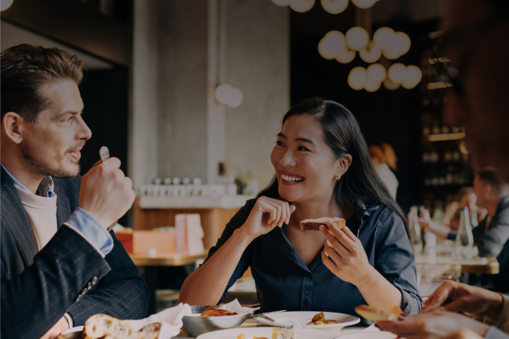 Multiethnic group of successful people having casual lunch in restaurant.